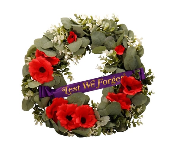 A wreath of flowers and a purple ribbon
Description automatically generated