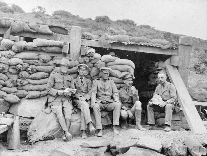 Officers of the 1st Royal Australian Naval Bridging Trains seated outside the sandbagged dugout known as the "Wardroom".