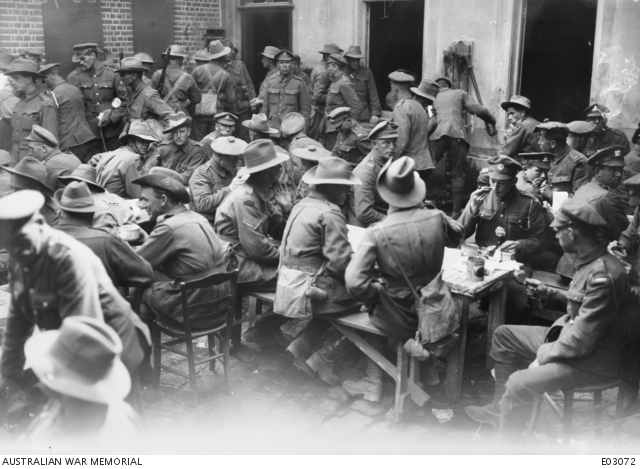 Australian and British soldiers enjoying coffee and biscuits in the Australian YMCA at Corbie, France, August 1918.