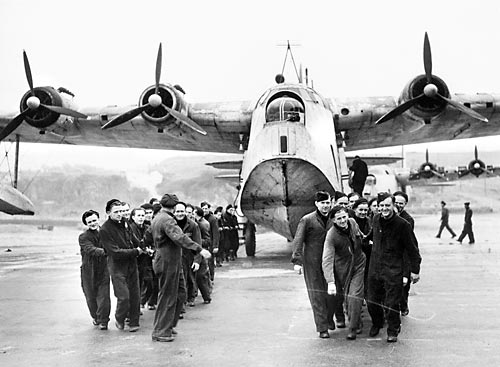 Ground crew of 10 Squadron RAAF haul a Sunderland flying boat ashore for maintenance at RAF Mount Batten, Plymouth, England, May 1945.